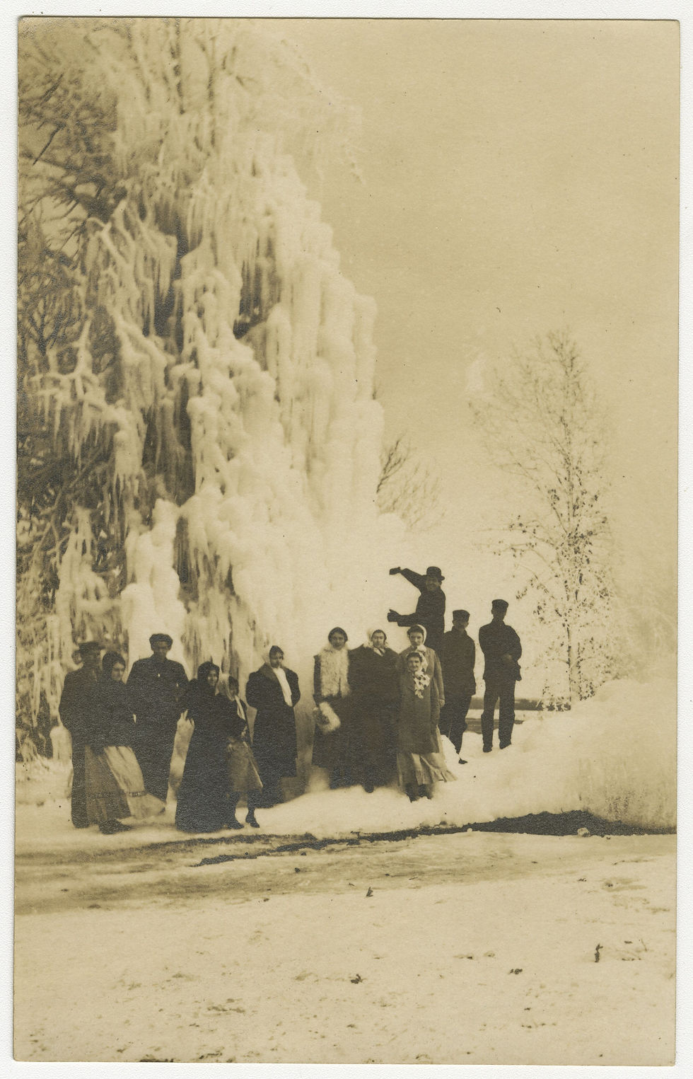 Unidentified men and women pose in front of ice accumulation on a tree, February 20, 1912. Image from the Postcards & Photographs collection.