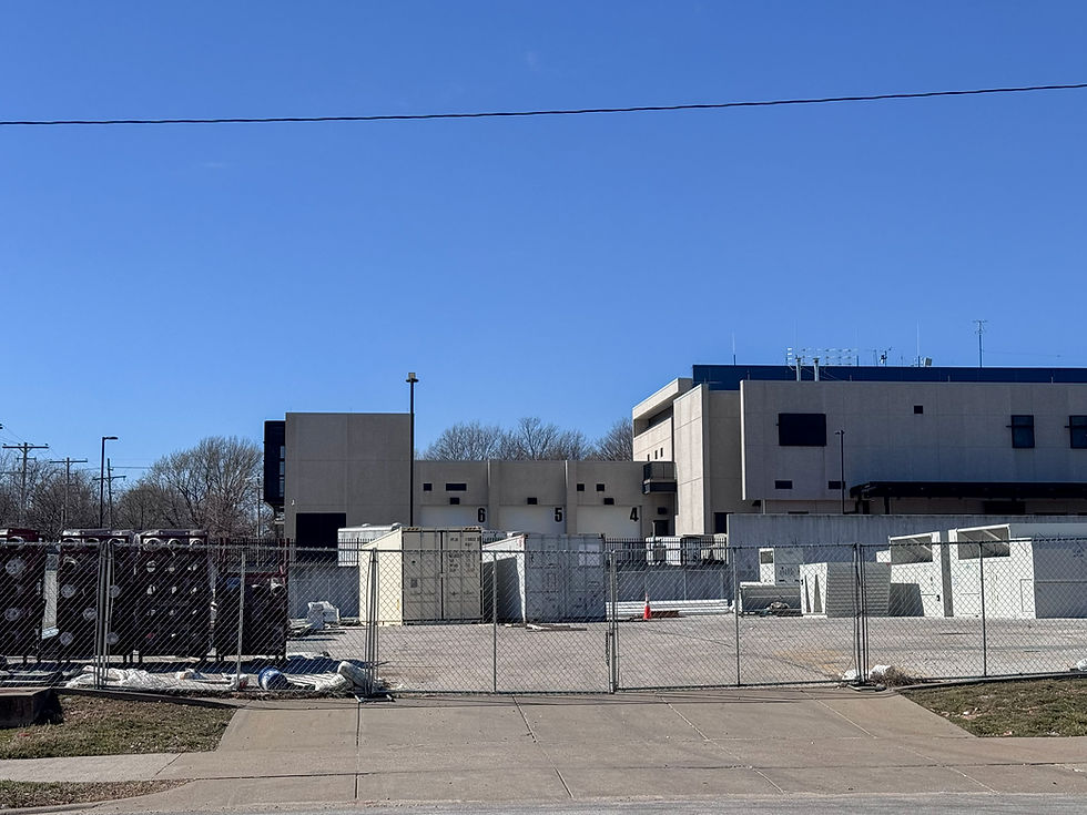 A fenced-off lot near the Greene County Public Safety Office. The lot is largely empty, save for a few storage containers.