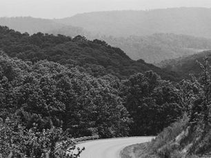 A black and white photograph depicting the rolling peaks of the Boston Mountains in Arkansas.