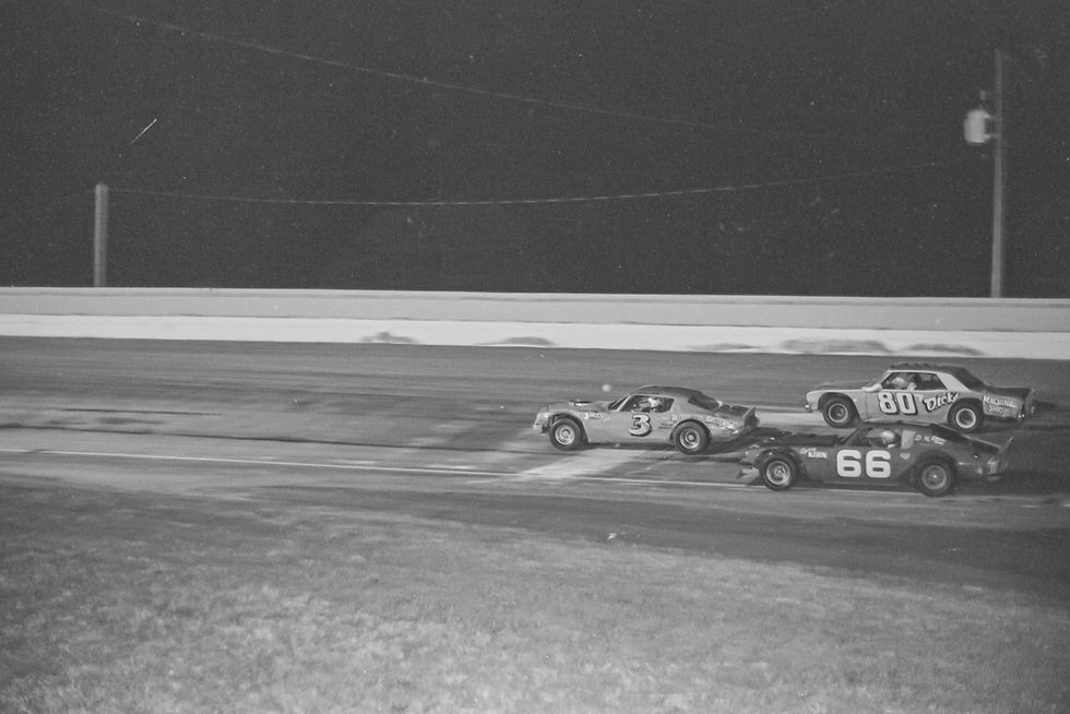 Drivers race in the 1976 Missouri State Asphalt Championship at Springfield's Fairgrounds Speedway. Larry Ball narrowly leads Rusty Wallace and Dave Williams.