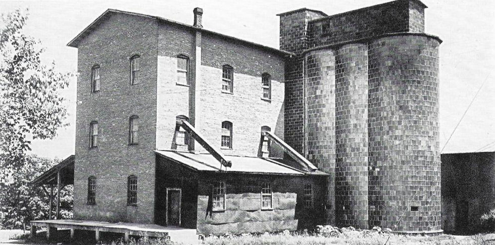 A black and white photograph of Bonner Mill in Buffalo, Missouri as it appeared in 1916. The mill is a three-story brick building with attached brick silos.
