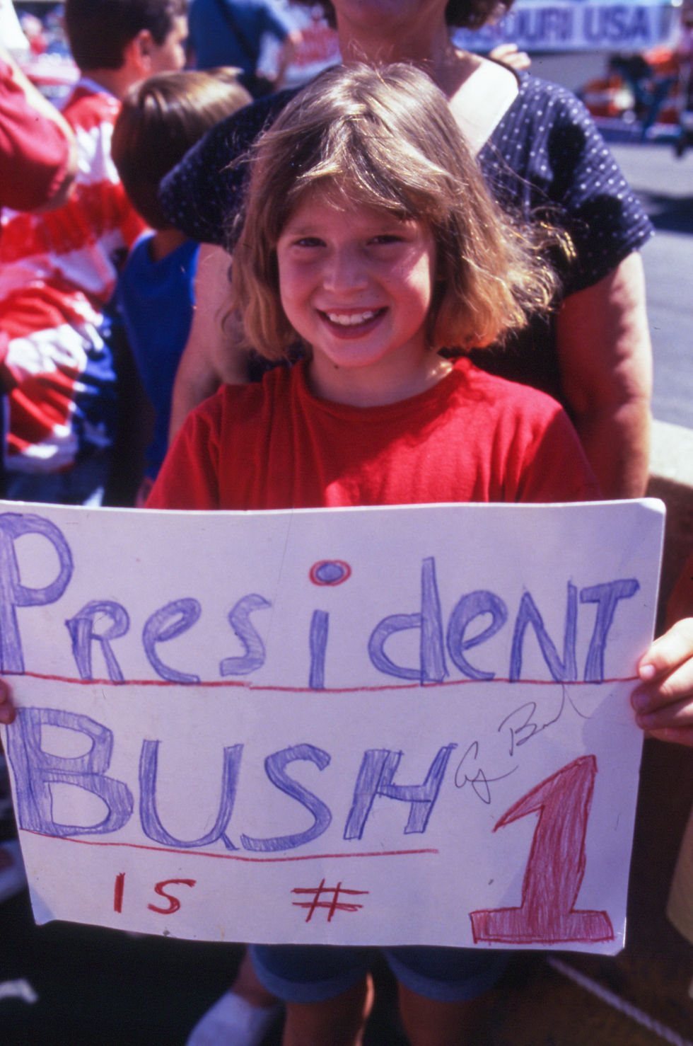 Eight-year-old Erin Osburn holds an autographed sign reading "President Bush is #1" at Marshfield's 1991 Fourth of July parade.