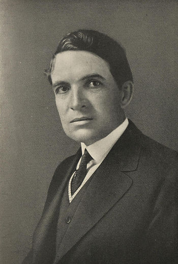 A half-length black and white portrait of John T. Woodruff. Woodruff has slicked dark hair, dark eyes, a heavy brow, and is wearing a suit.