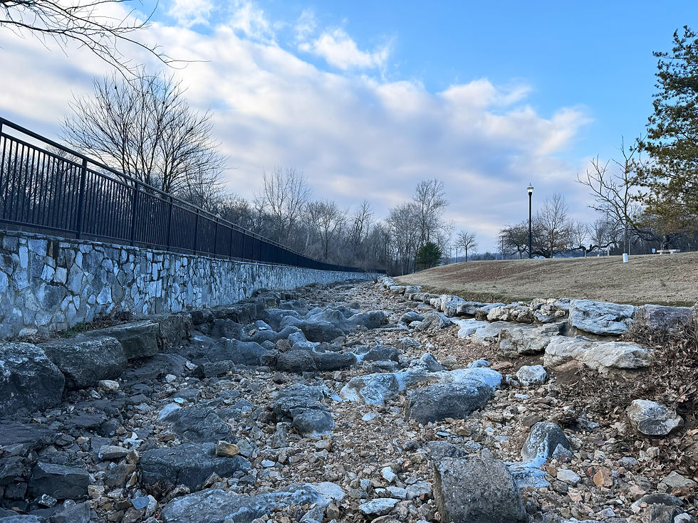 The dry bed of Galloway Creek in Sequiota Park. Rocks and boulders of various size are in the creekbed.
