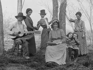 A black and white photograph of an early 20th century Ozarks family posed outside.
