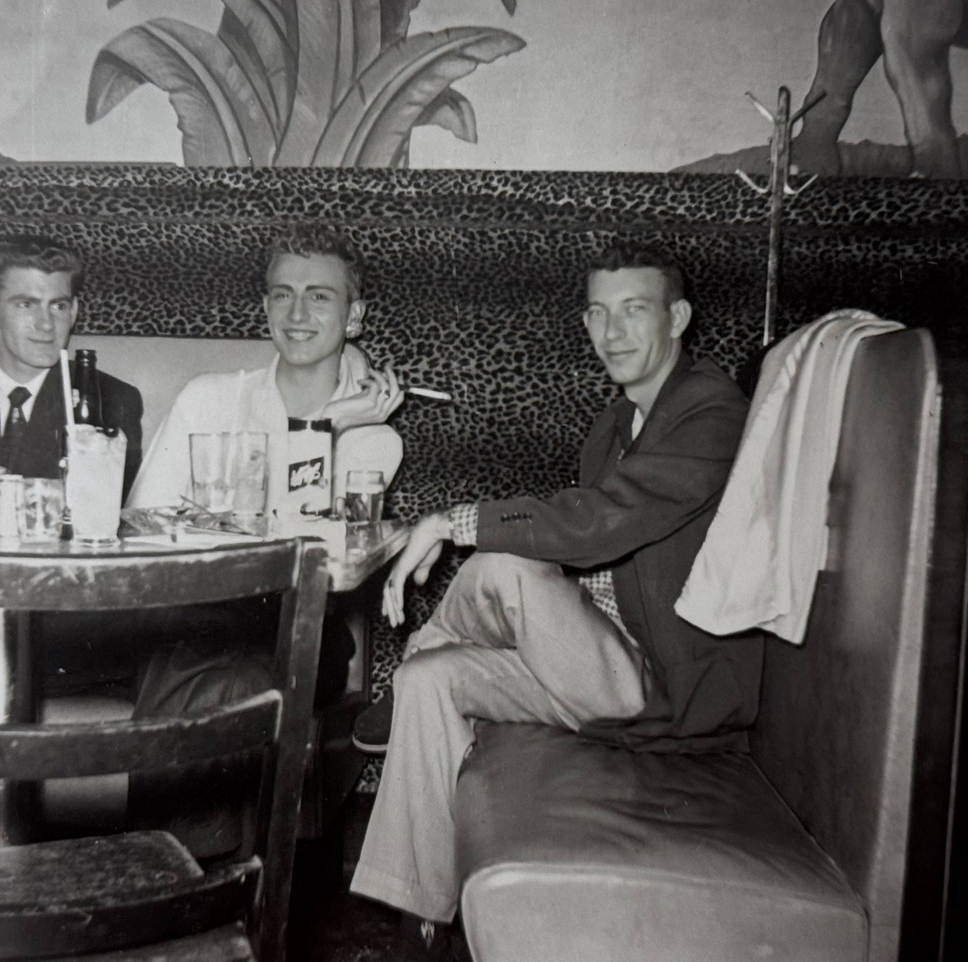 Three unidentified men sit at a table.