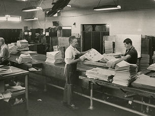 Employees of Springfield Newspapers, Inc. fold and sort new newspaper issues.