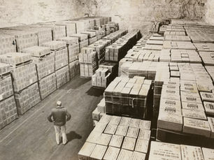 Cecil Swinnhart stands amid boxes of government cheese stored by the General Warehouse Corporation.