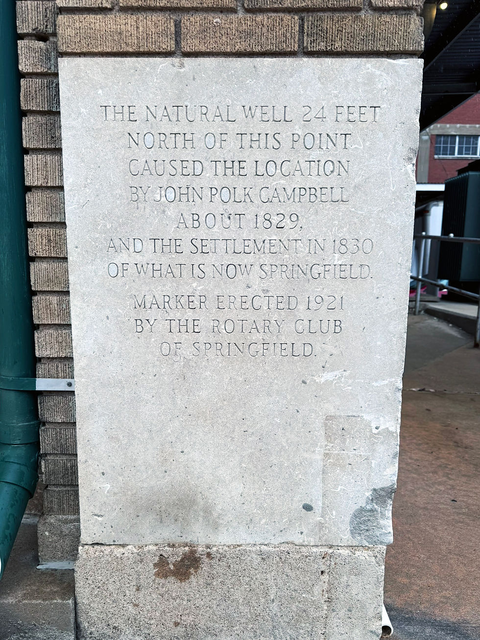 An inscription that says "The natural Well 24 feet north of this point caused the location by John Polk Campbell About 1829, and the settlement in 1830 of what is now Springfield. Marker erected 1921 by the rotary club of Springfield.
