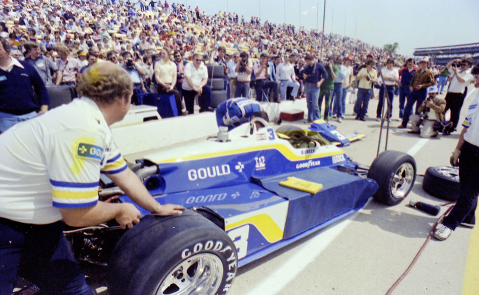 Fans and journalists watch as Bobby Unser’s race car sits on pit road in 1981. With the front wing off, Unser is inspecting the left front corner of his car.