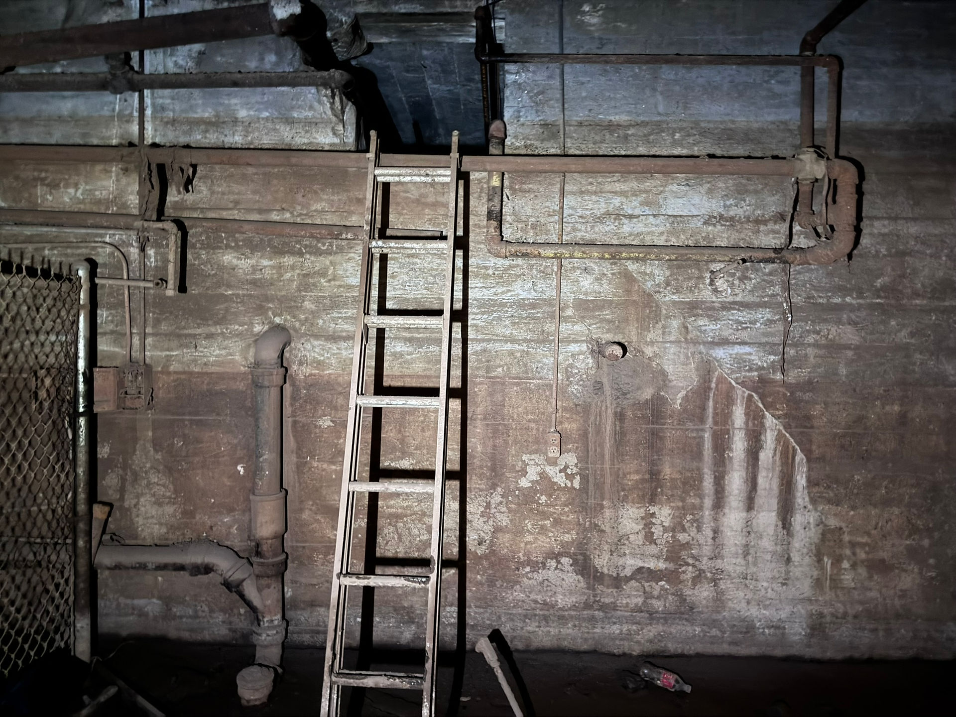 A ladder leads to a dark crawlspace abnear the ceiling