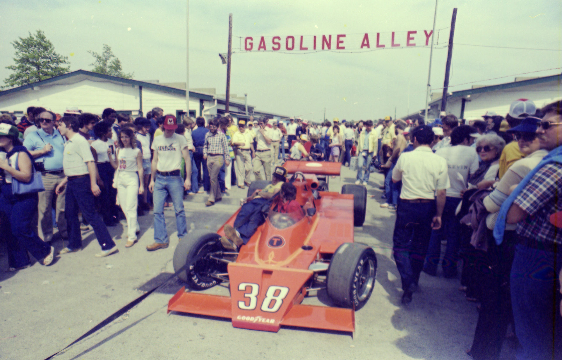 A pit crew member catches a ride with Jerry Karl,  who started 31st and finished 15th in 1981.