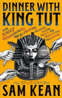 Yellow book cover titled "Dinner with King Tut" by Sam Kean. Features a Pharaoh's mask and hands holding food against an ancient Egyptian-themed design.