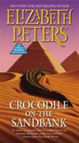 Book cover of "Crocodile on the Sandbank" by Elizabeth Peters shows a crocodile on sand dunes with pyramids in the background.