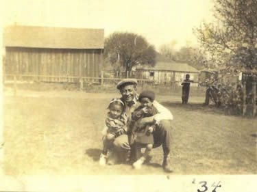 Old photo of a man hugging two children