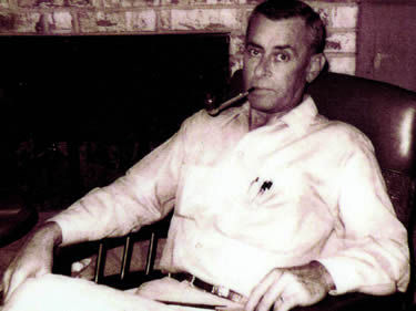 Black and white photograph of Max Hunter siting in a chair.