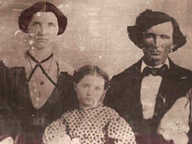 Black and white photograph of a man, wife, and child from the 1860s.